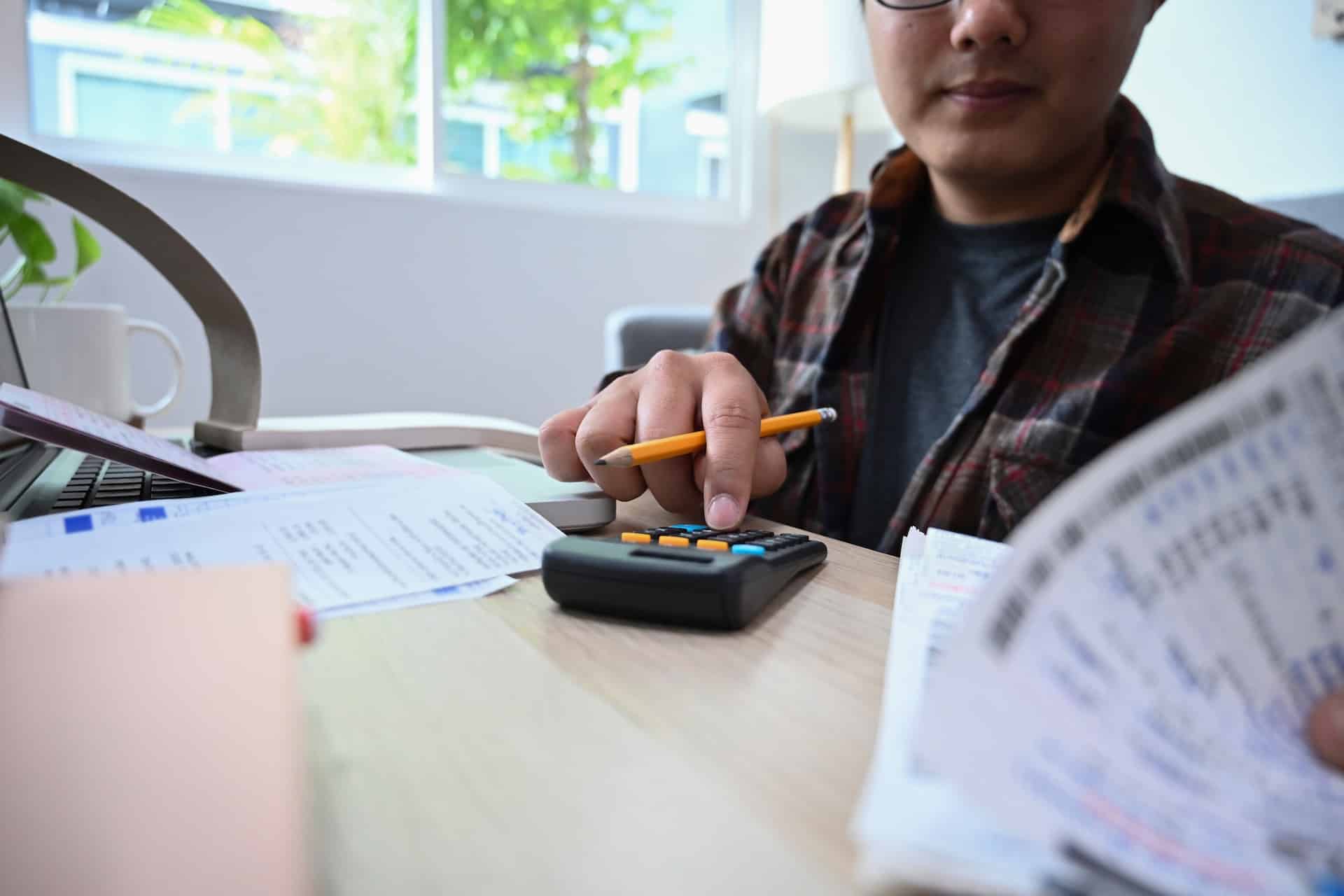 an image of a business owner working out the company payroll to avoid late payroll penalty